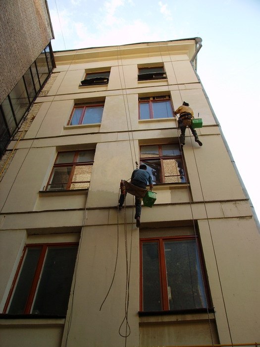 Окраску фасада дома выполняют специализированные альпинисты